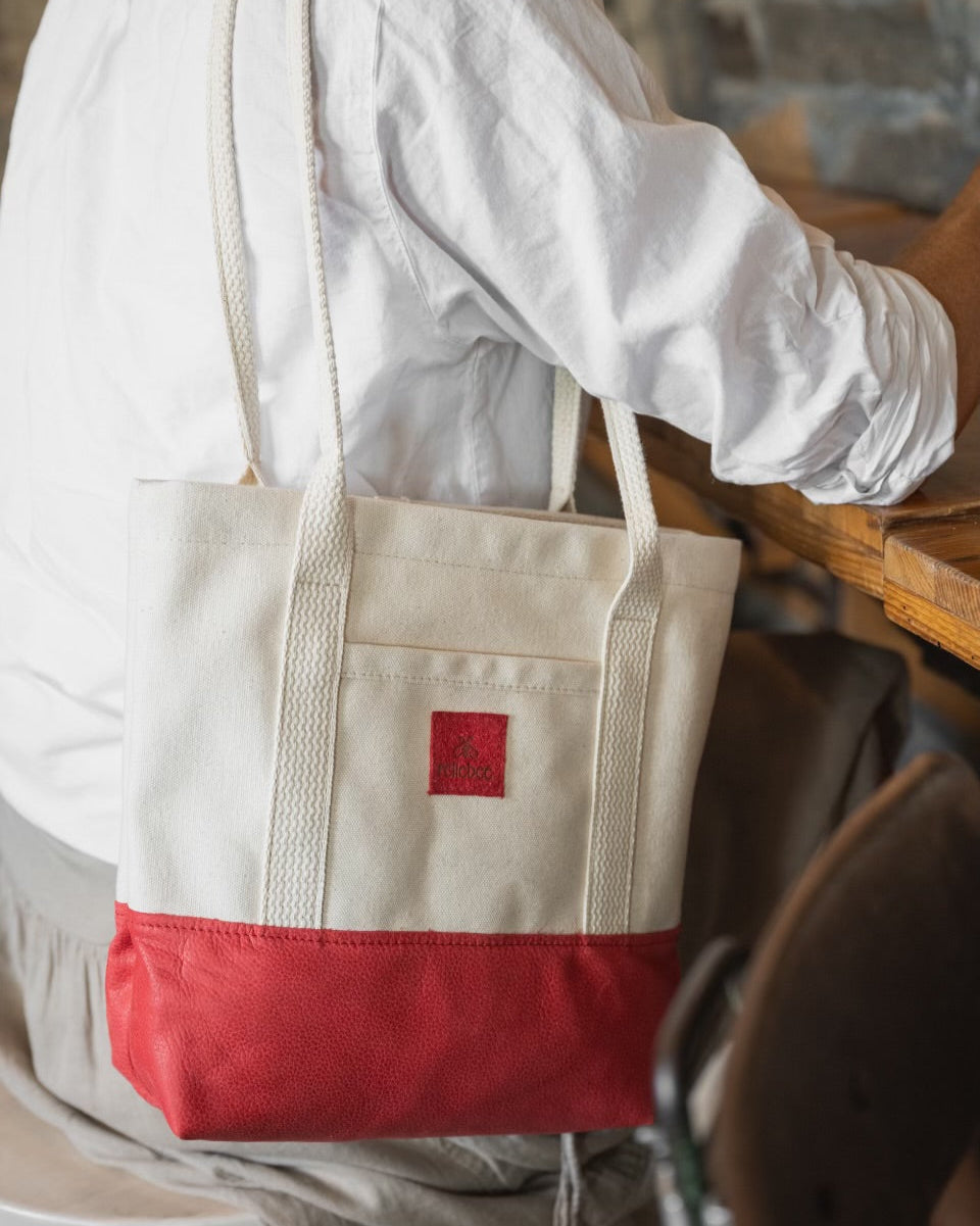 Image of model wearing product Little Everyday Tote in Cherry + Canvas: Just like the Everyday but smaller. This is the perfect bag to throw on your shoulder everyday for any casual outing. Holds a water bottle, keys, clutch, sunglasses and a book. Outside pocket perfect spot for your phone. It's a cute bag!