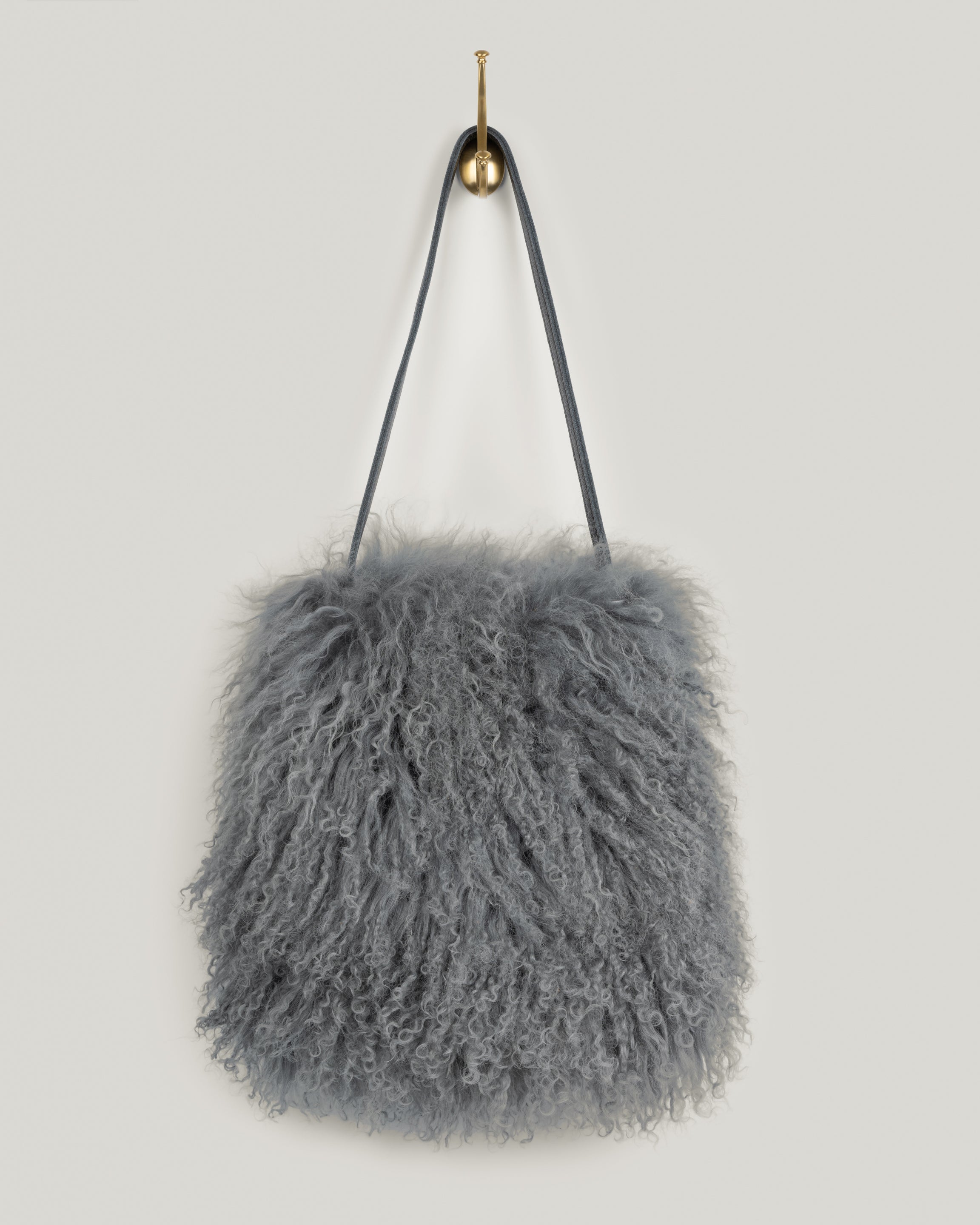 Image of the product Mongolian in Dove Grey(lined):The Mongolian is loaded with personality. Simple shape. Single leather strap with topstitching. Just big enough for your phone, water bottle, sunglasses, clutch, wallet and keys. This bag blows in the wind and moves right along with you. You won't want to put it down. Vintage vibe. Lined with an inside pocket.