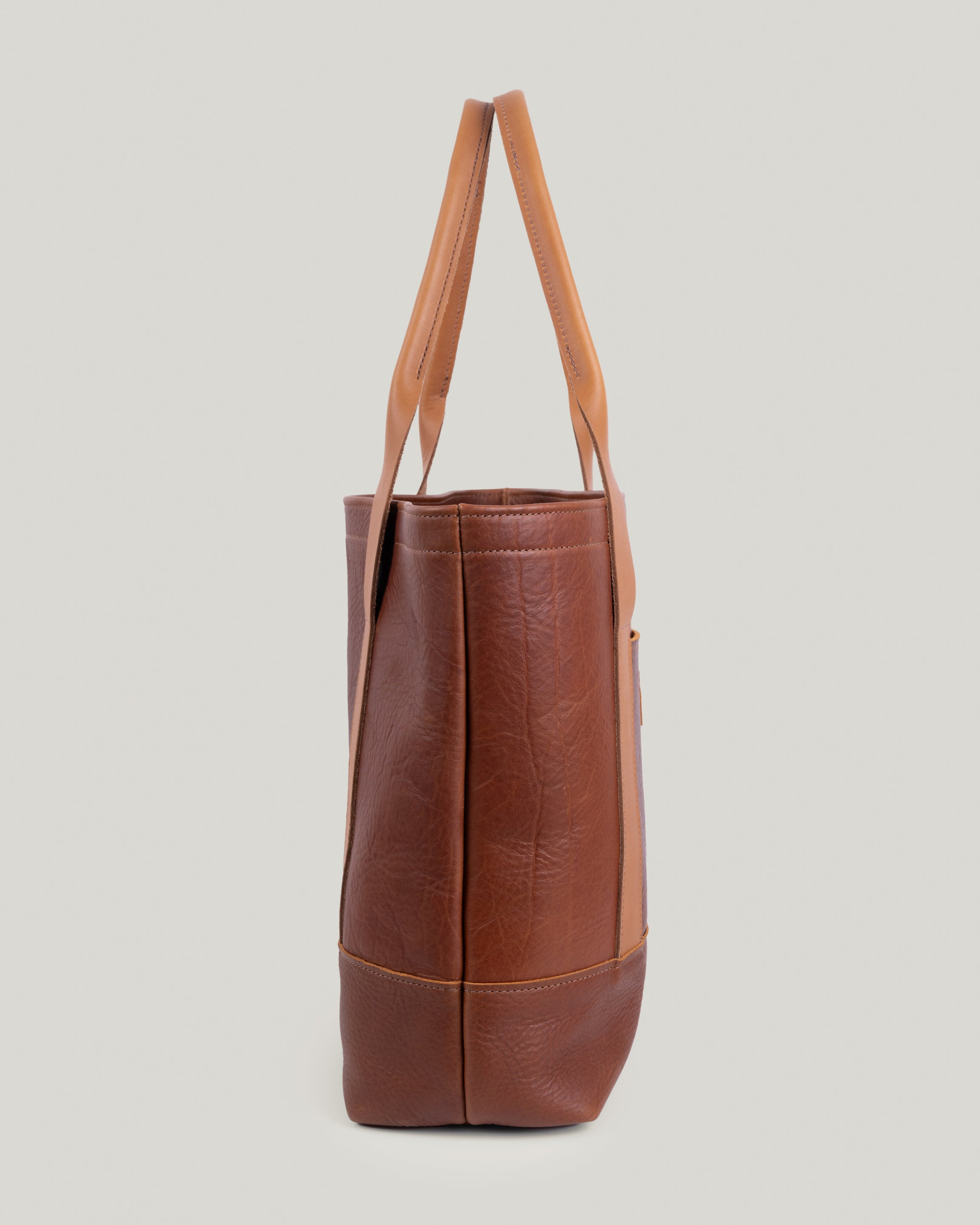 Side view of Rellebee Berkshire tote bag with spacious silhouette and sturdy leather handles