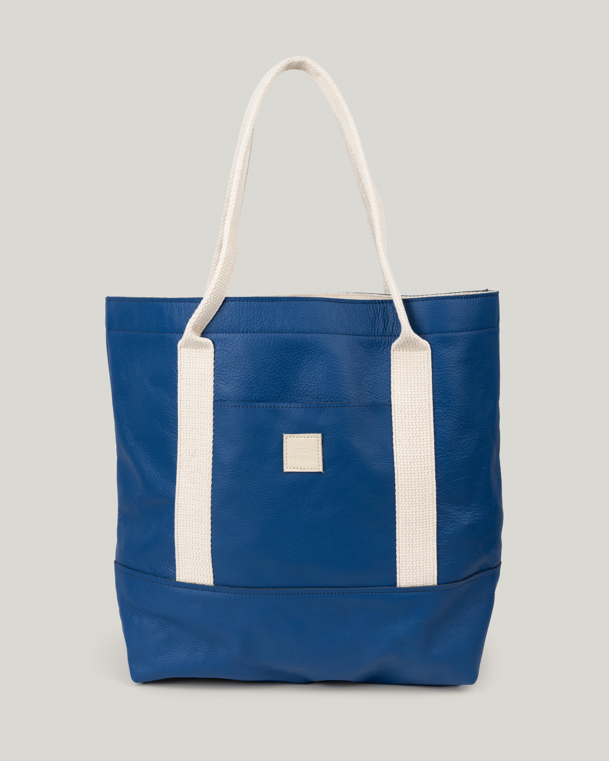 Image of product Everyday Tote: Leather on Leather in Electric Blue: Leather base and a leather body. Nice and roomy. Great casual bag for work, school, and everyday living. The outside pocket is the perfect spot to slip your phone and keys in.