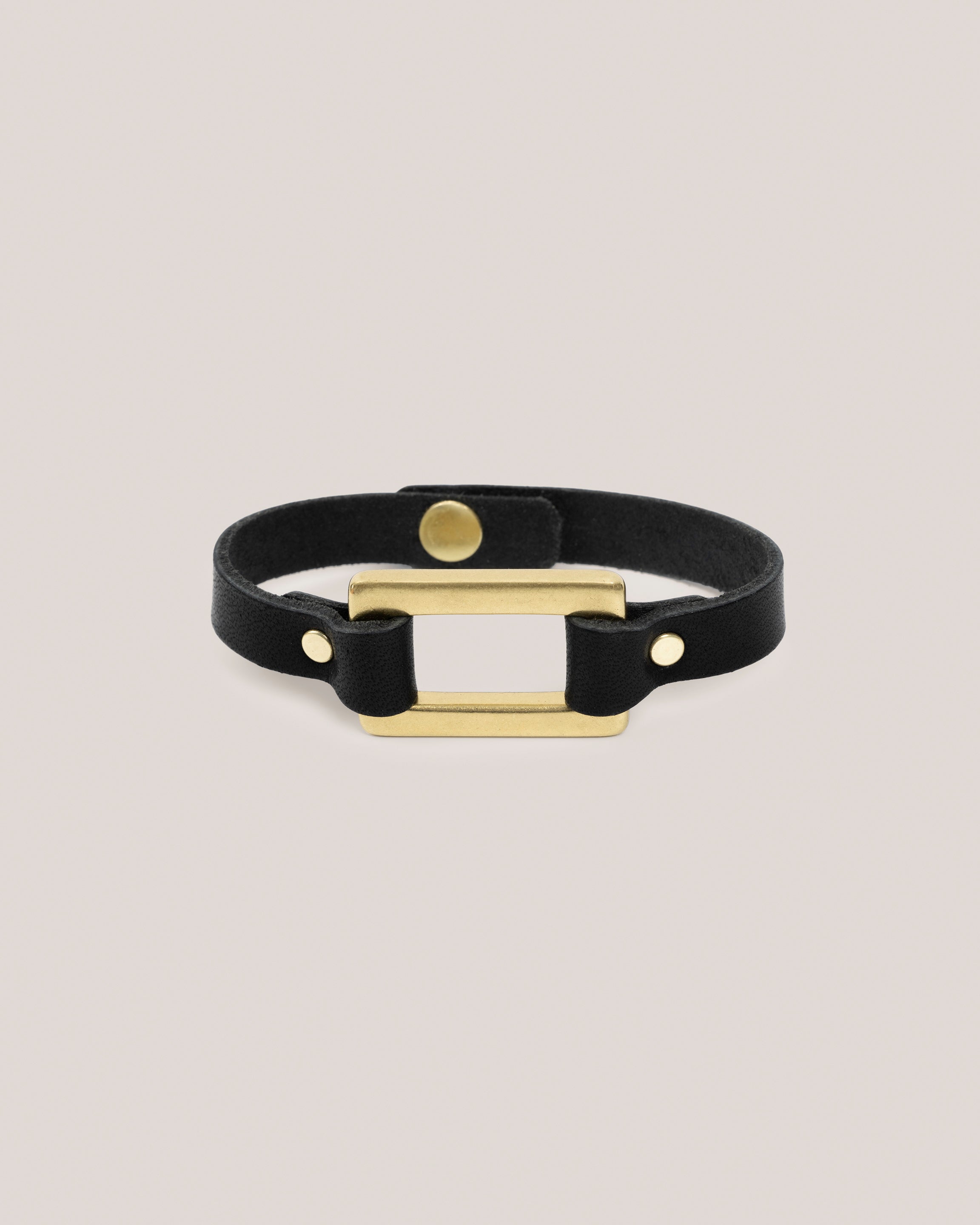 Image of the Stirrup bracelet in black: Made from sturdy 5 ounce full grain leather. A nod to the horse country. Dress it up. Dress it down. Looks great layered. Pretty polished brass rectangle ring adds a touch of sophistication. Made by our leather craftsmen friends in Wyoming. 
