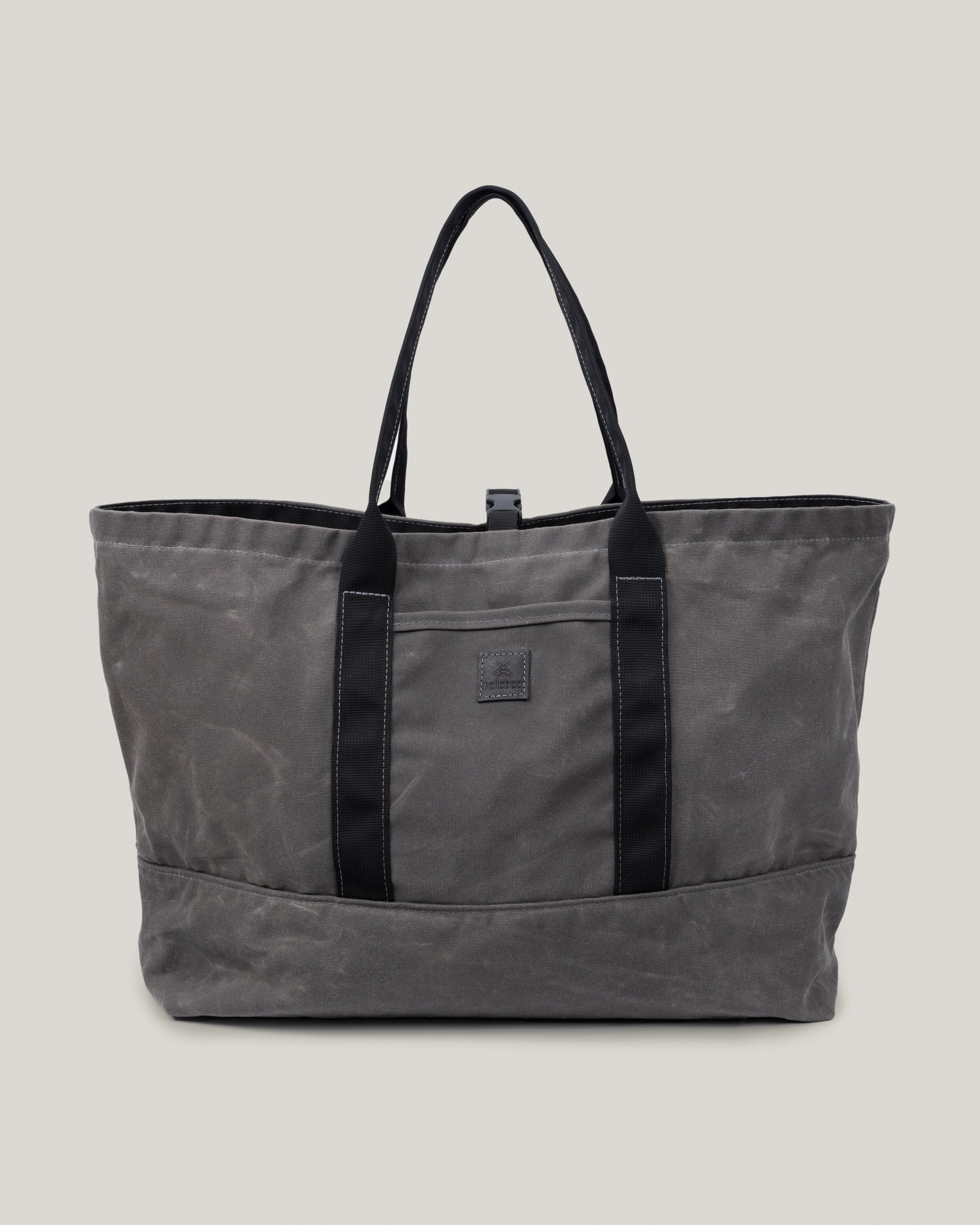 Image of the product Utility tote in charcoal waxed:The Utility Tote is for the quick getaway. Nice and roomy and holds everything you need for a weekend trip or any little adventure. Outside pocket to slip your phone in. Cinch it down with the canvas snap strap.