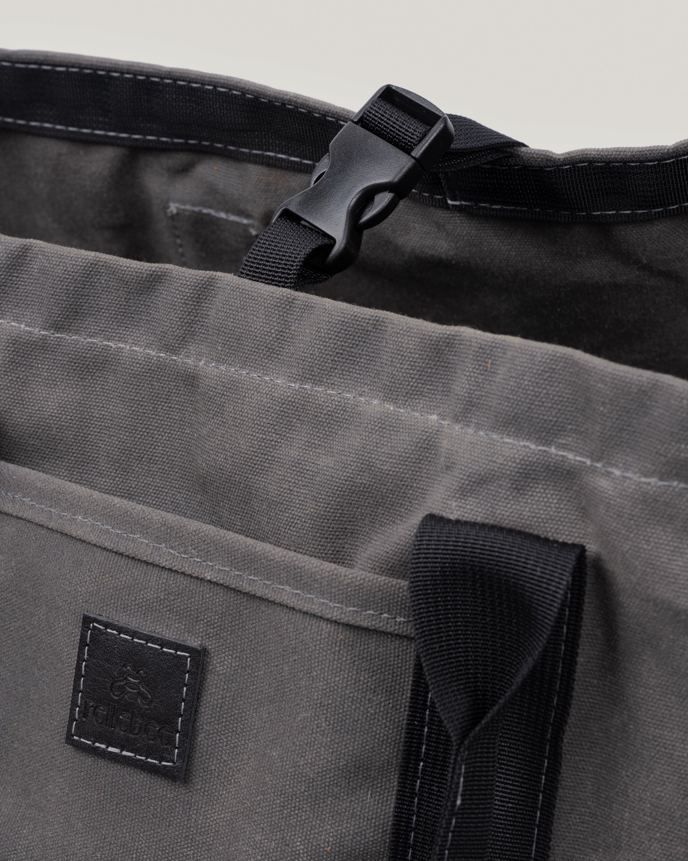 Closeup image of the utility tote in charcoal waxed showing the interior and the clip to keep the tote closed