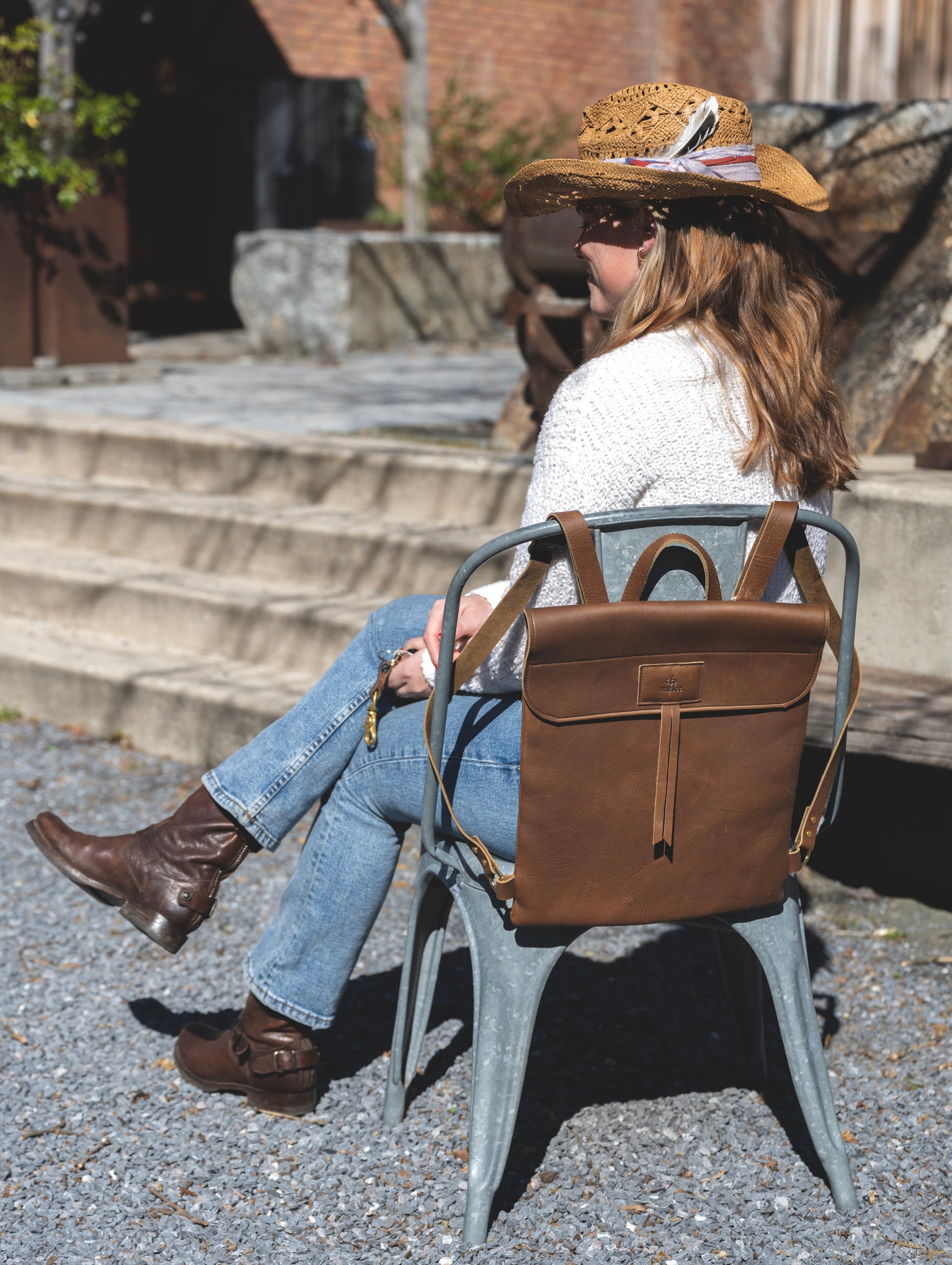Image of model sitting down with Messenger Pack hanging on to chair