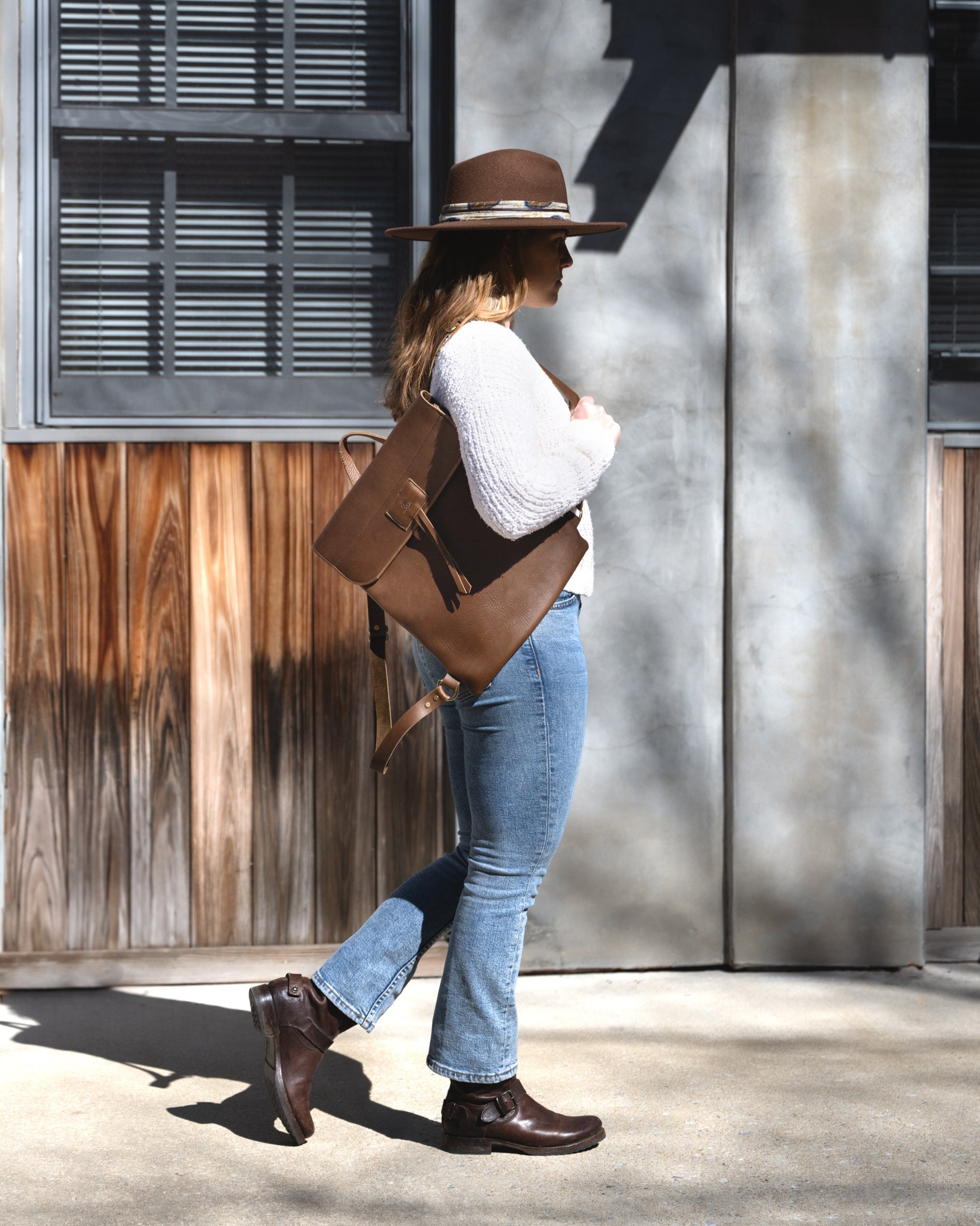 Side view image of model wearing the Messenger Pack in Olive Brown