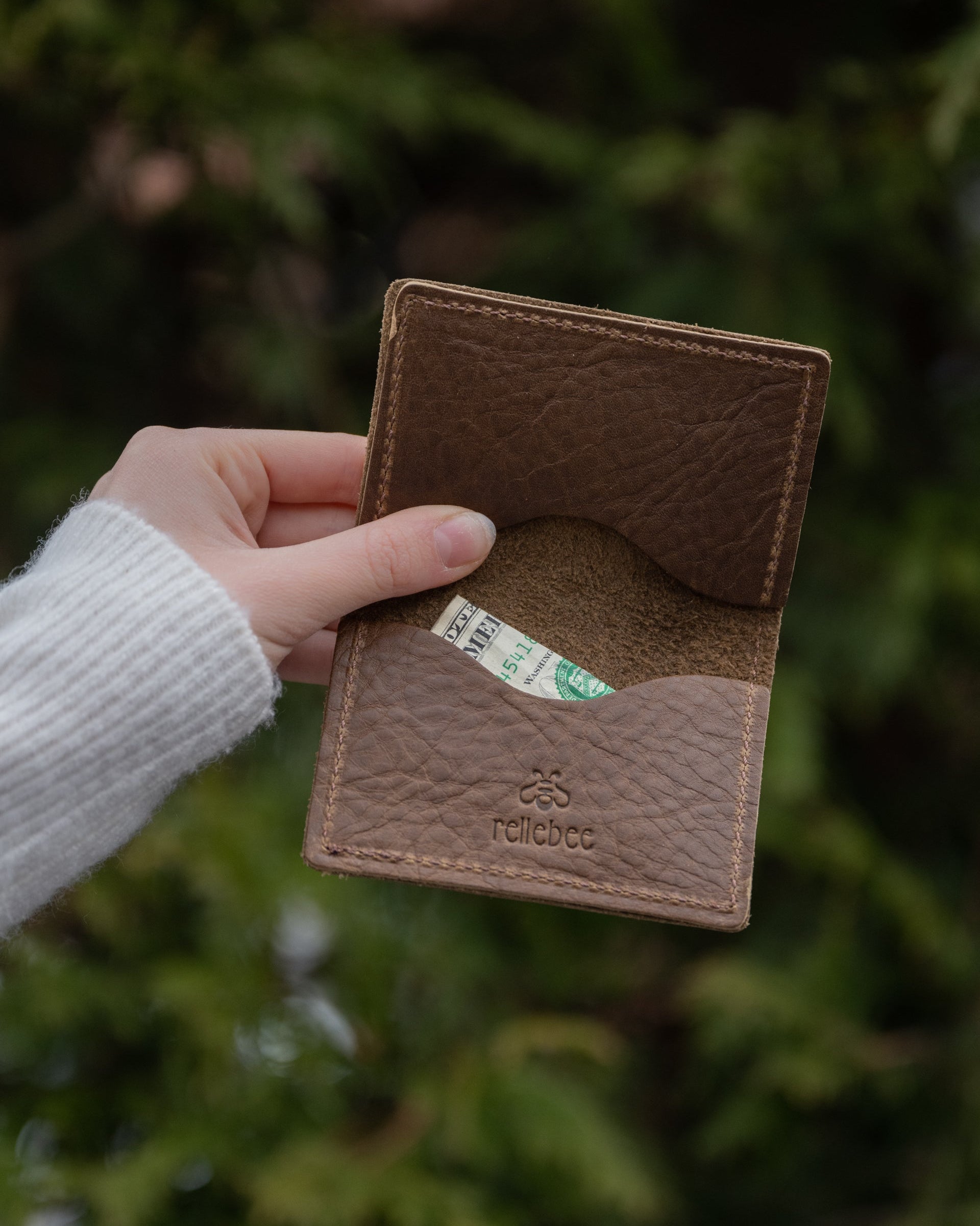 Image of model holding the milk chocolate minimalist wallet open. Showing the inside
