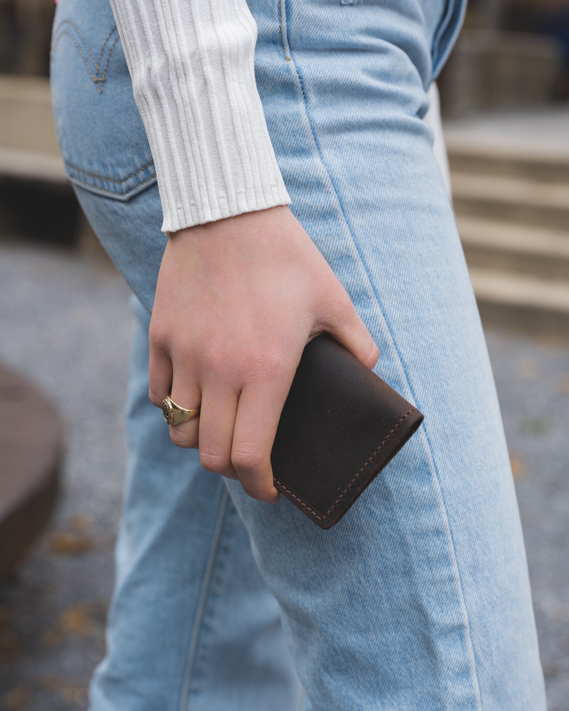 Image of model holding the Minimalist wallet in dark chocolate in their hands