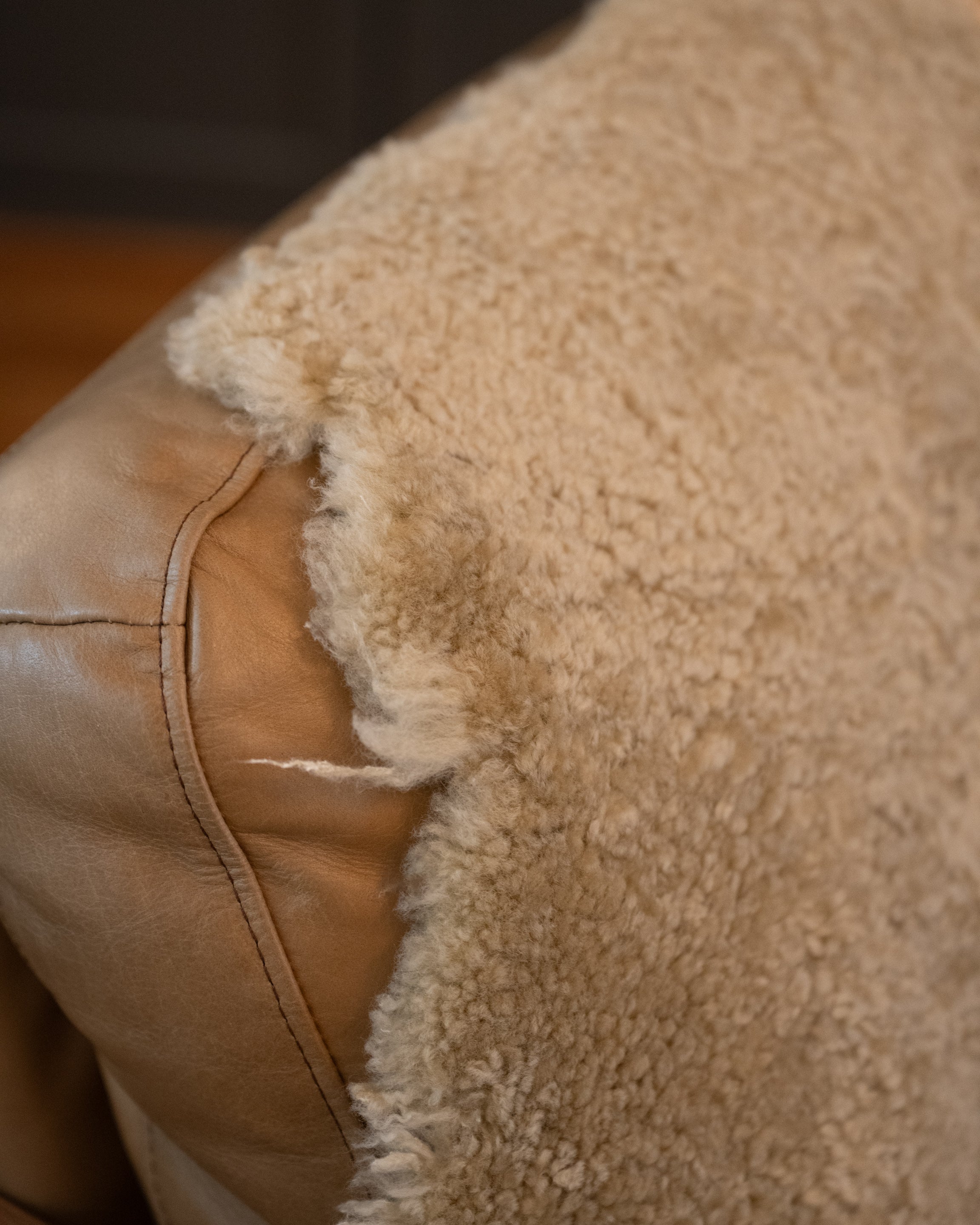 Close up image of New Zealand Sheepskin in Natural colour covering a chair