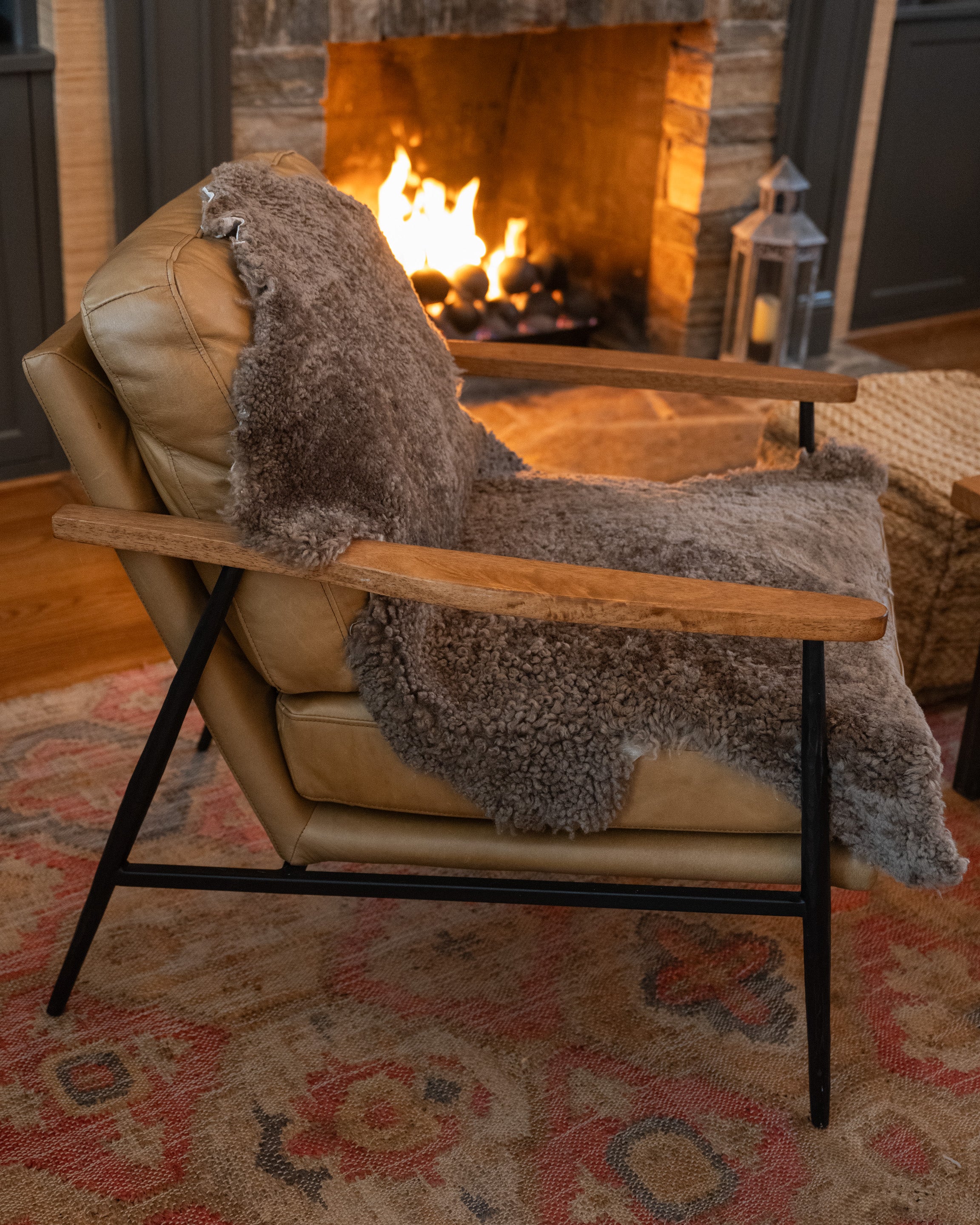 Image of product New Zealand Sheepskin in Mushroom color on a chair: Each hide is unique with its own variations and texture that make these natural products so special. Their rustic and authentic feel will add warmth to any room. Drape one over a chair. Lay one down in front of your hearth. Perfect cozy spot for man's best friend. Ethically sourced.