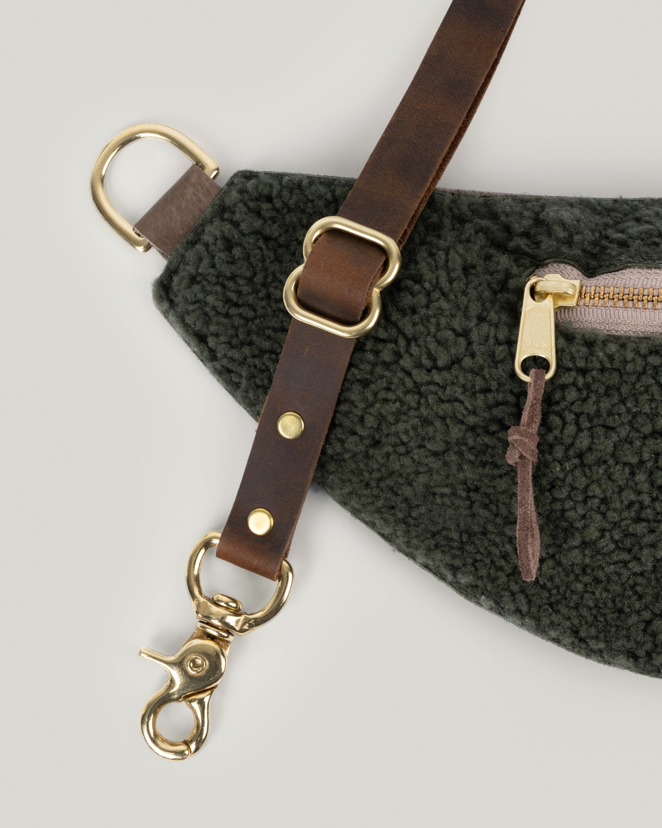 Closeup view of the Classic sling: shearling in Spruce. Showcasing the strap and hook.