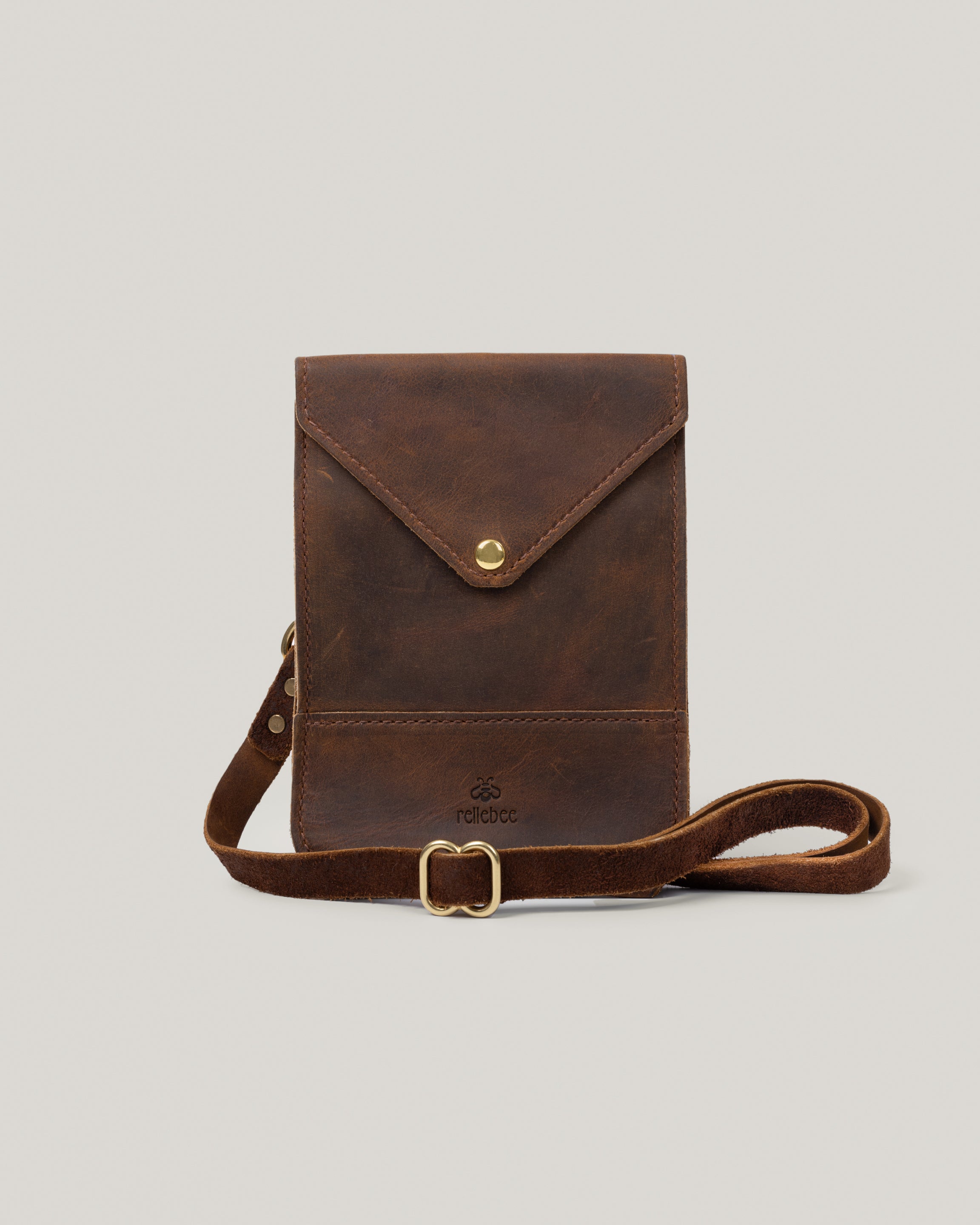 Image of the product Envelope sling:Stitched from a rugged Crazy Horse hide from Wisconsin. Adjustable leather bridle strap. The Envelope Sling can be worn with a shortened strap over the shoulder or lengthened to wear as a cross body. It lies flat against the body and is big enough for your phone, mini wallet and keys. Simplest of bags but loaded with character and personality.