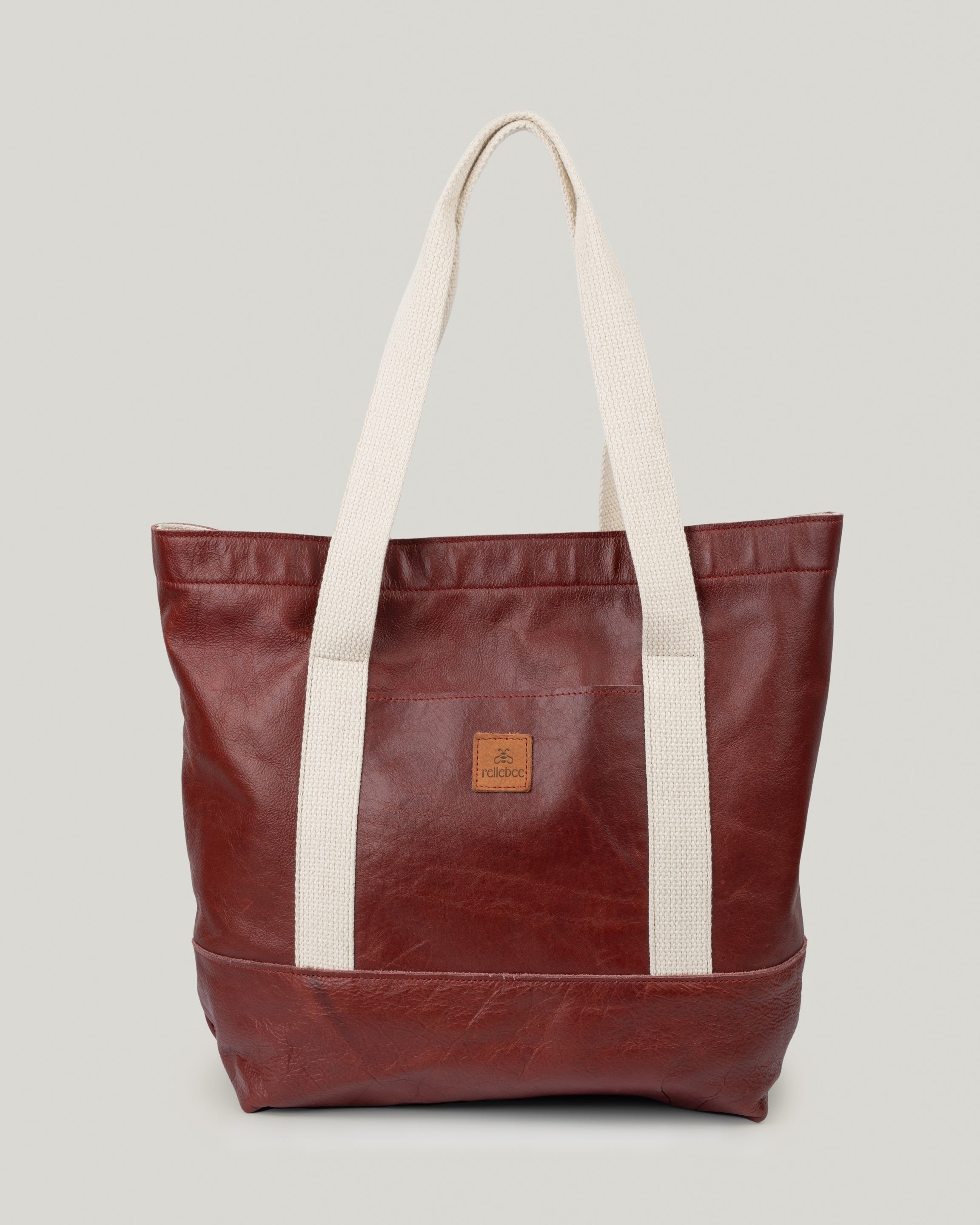 Image of product Everyday Tote: Leather on Leather in Crimson: Leather base and a leather body. Nice and roomy. Great casual bag for work, school, and everyday living. The outside pocket is the perfect spot to slip your phone and keys in.