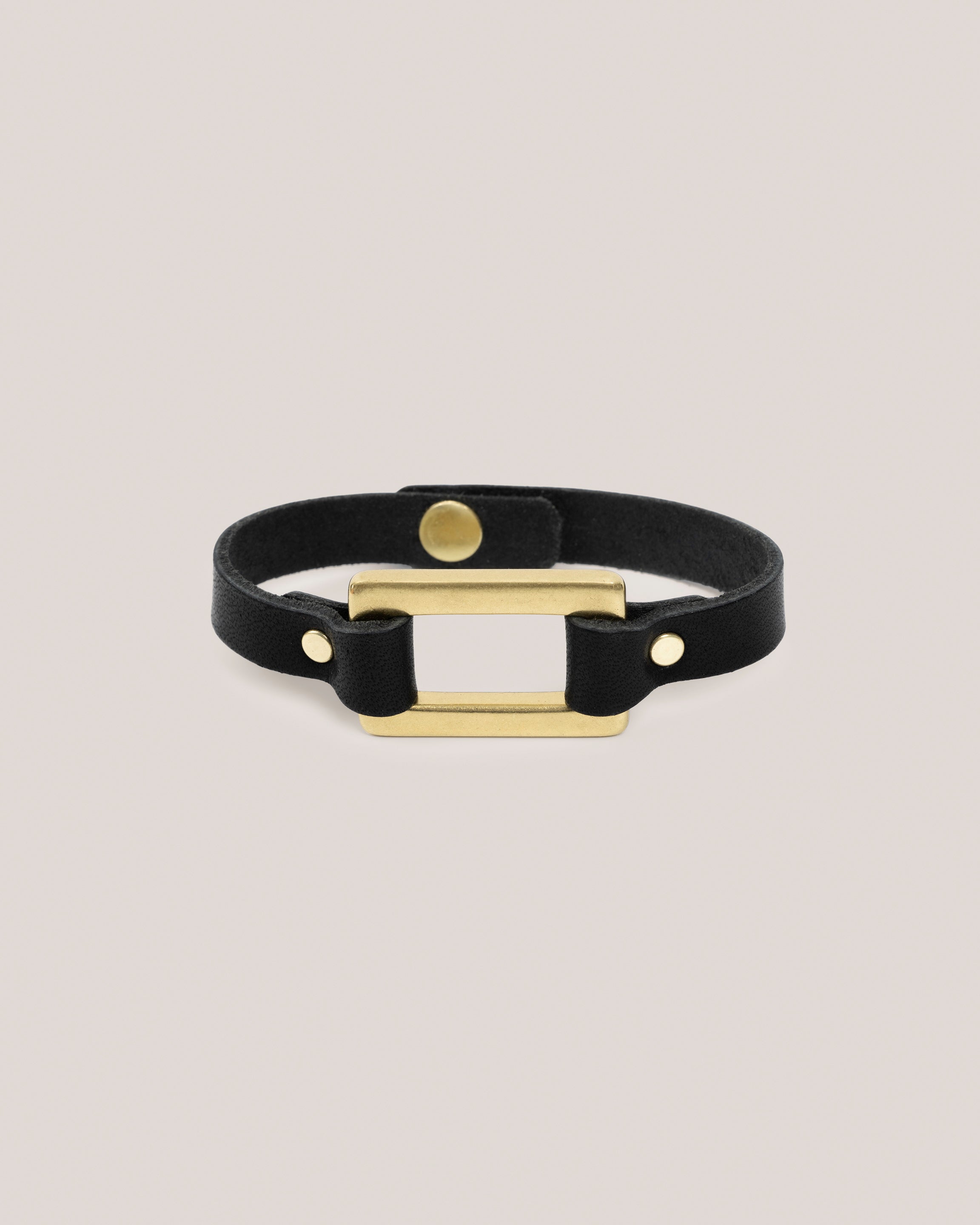 Image of the Stirrup bracelet in black: Made from sturdy 5 ounce full grain leather. A nod to the horse country. Dress it up. Dress it down. Looks great layered. Pretty polished brass rectangle ring adds a touch of sophistication. Made by our leather craftsmen friends in Wyoming.&nbsp;