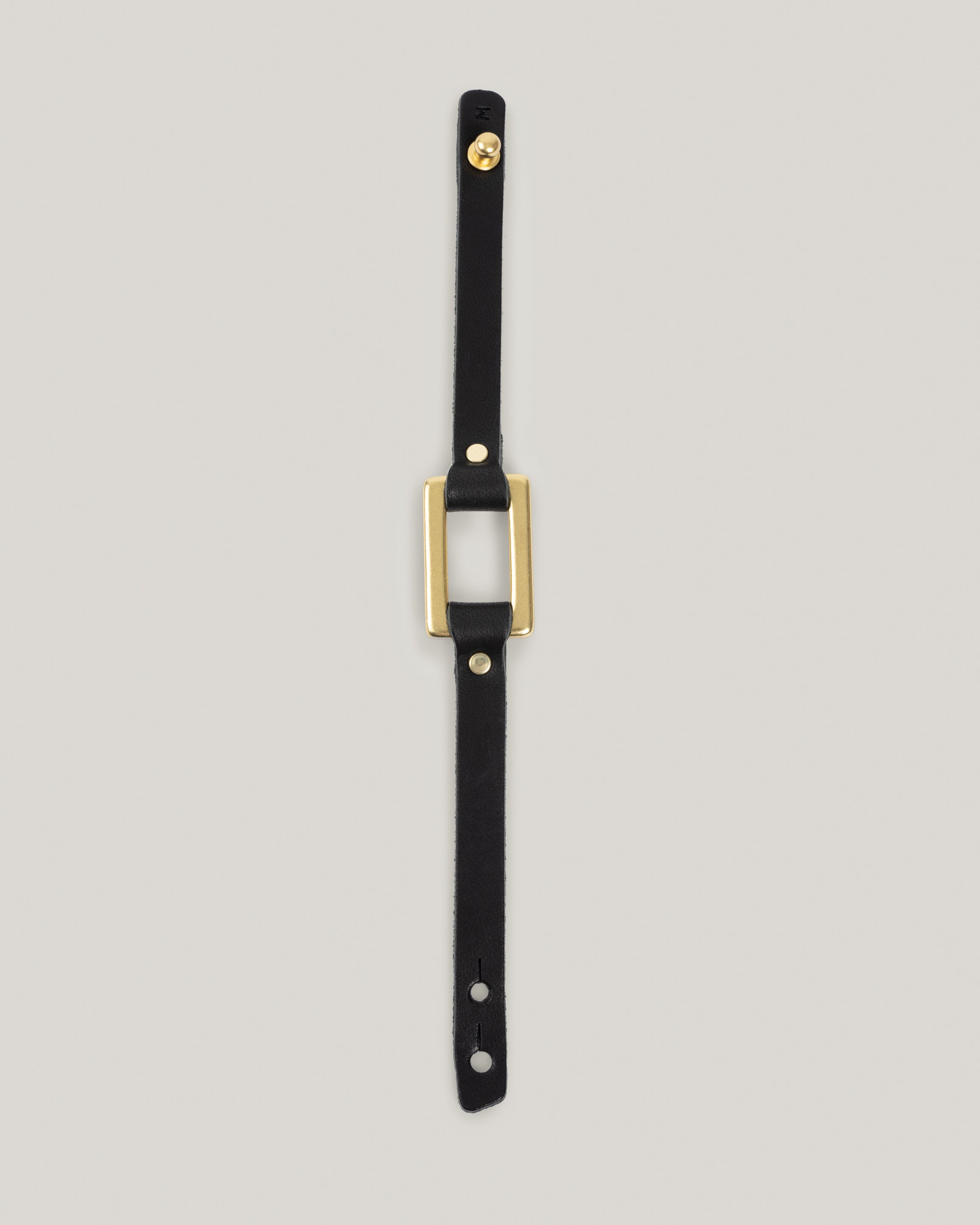 Image of the stirrup strap bracelet in black fully laid out 