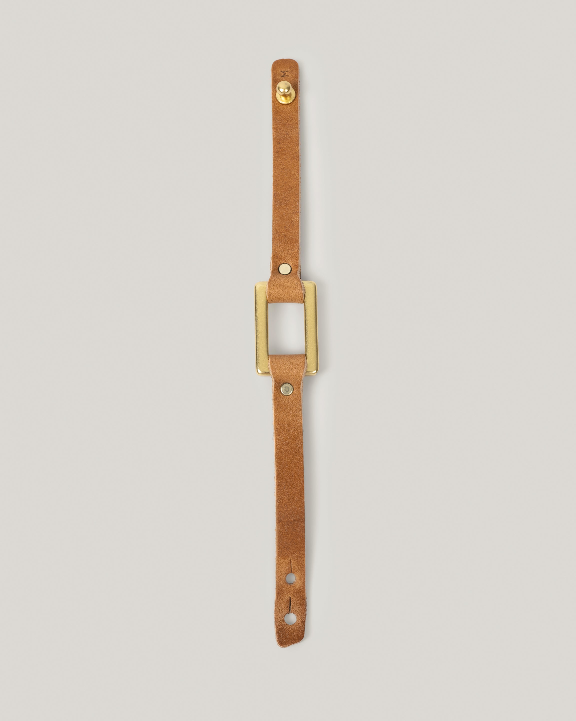 Image of the stirrup strap bracelet in sand fully laid out 