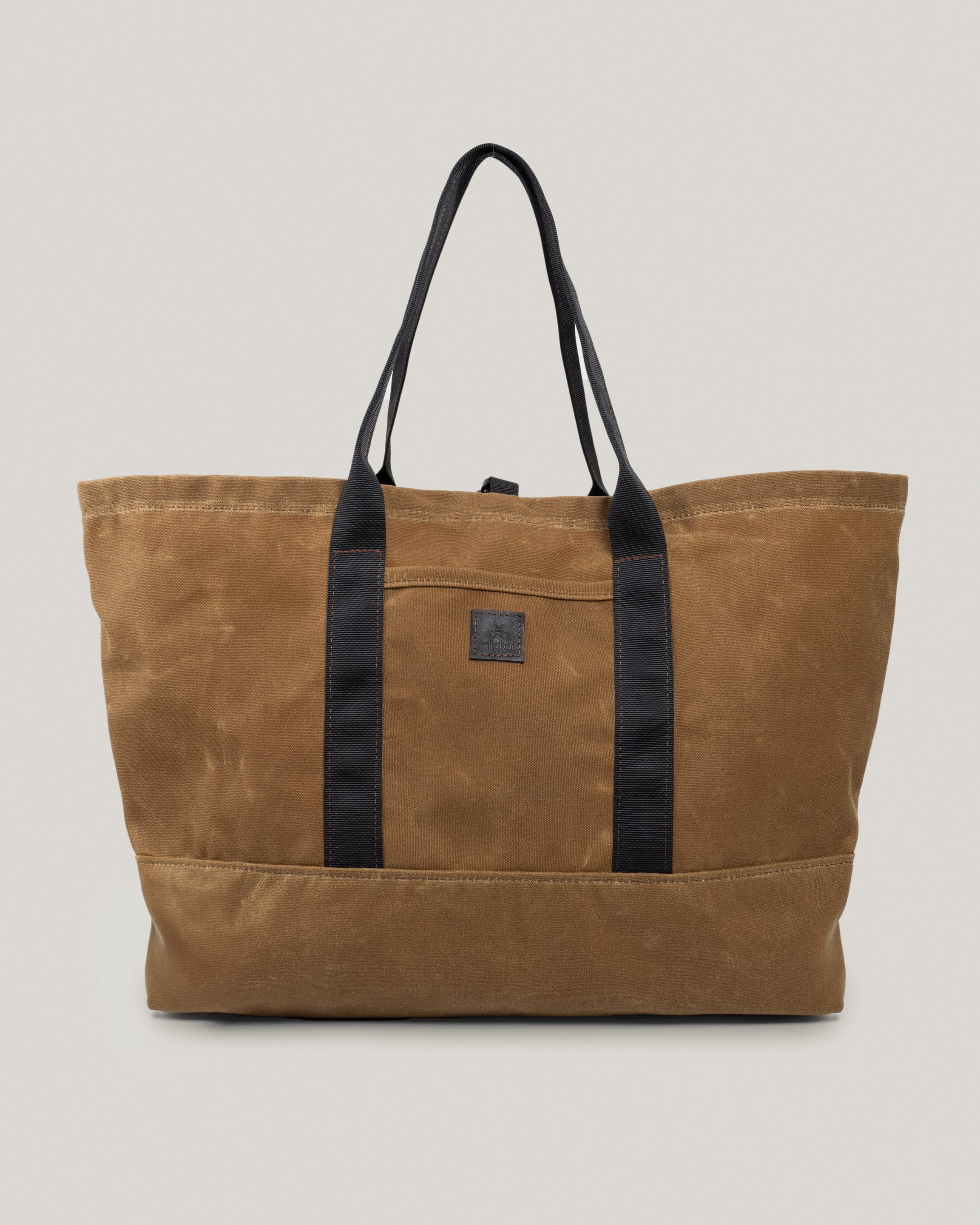 Image of the product Utility tote in umber waxed:The Utility Tote is for the quick getaway. Nice and roomy and holds everything you need for a weekend trip or any little adventure. Outside pocket to slip your phone in. Cinch it down with the canvas snap strap.