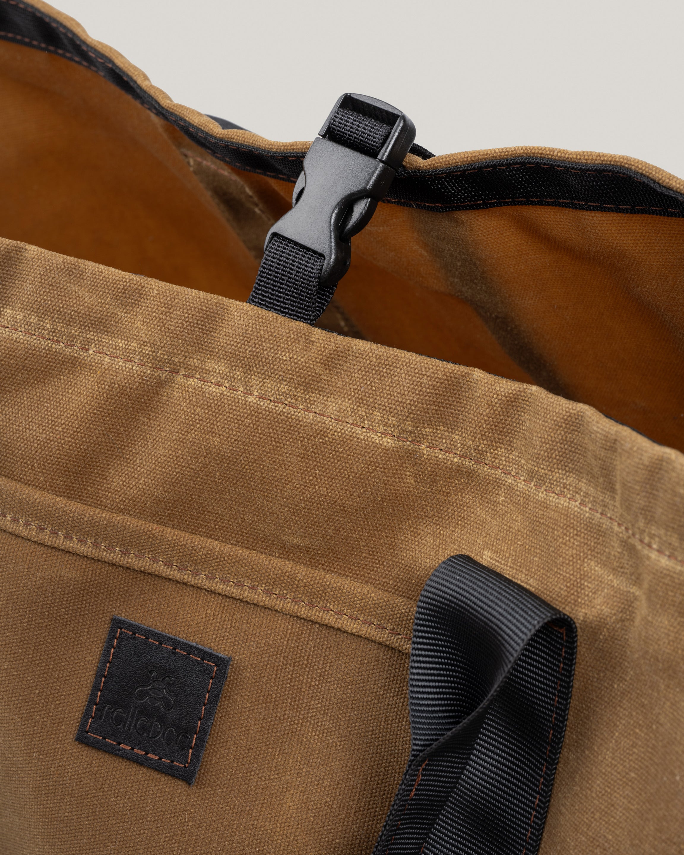 Closeup image of the utility tote in umber waxed showing the interior and the clip to keep the tote closed