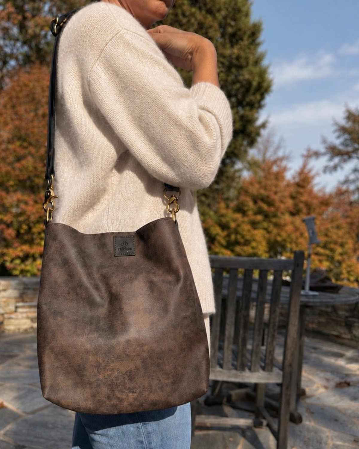 Woman wearing The Slouch bag crossbody outdoors in autumn
